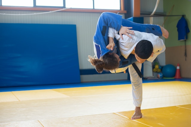 Chłopiec przewracający dziewczynkę w judo